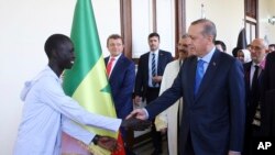 Turkey's President Minister Recep Tayyip Erdogan shakes hands with an African student as he arrives to receive a honorary doctorate from Medical Sciences University in Istanbul, Sunday, Nov. 6, 2016. 