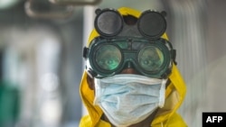 A cleaning staff wears protective gear to disinfect a metro carriage against the spreading of the COVID-19 coronavirus in Addis Ababa, Ethiopia, March 20, 2020.