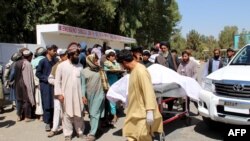 Afghan villagers carry a dead body on a stretcher outside a hospital following an airstrike in Lashkargah, the capital of Helmand province on Sept. 23, 2019.