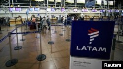 Passengers wait to check in for their flights at the departures area of Latam airlines inside the international airport in Santiago, Chile, Aug. 16, 2018.