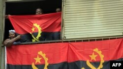 Une famille angolaise derrière le drapeau national à Luanda, le 9 janvier 2010.