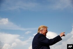 President Donald Trump speaks with reporters before boarding Air Force One at Morristown Municipal Airport in Morristown, N.J., Aug. 18, 2019.