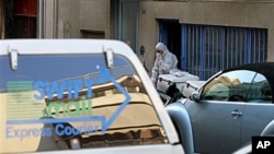 A Greek anti-terrorist police officer investigates a private delivery company after an explosion in Athens, 1 Nov 2010