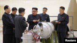 Pemimpin Korea Utara Kim Jong Un (tengah) tampak memberikan arahan mengenai pengembangan senjata nuklir dalam foto yang dirilis KCNA, Minggu (3/9). 