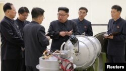 North Korean leader Kim Jong Un, center, provides guidance on a nuclear weapons development in this undated photo released by North Korea's Korean Central News Agency in Pyongyang, Sept. 3, 2017. 