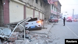 Damaged cars are seen amid rubble next to damaged buildings at Dahejia town following the earthquake in Jishishan county, Gansu province, China December 19, 2023. cnsphoto via REUTERS