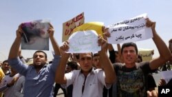 Warga Irak dari komunitas Yazidi meneriakkan slogan anti militan Islam di depan markas besar PBB meminta perlindungan internasional di Irbil, Irak, Senin, 4 Agustus 2014.