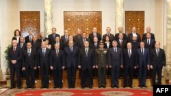 A handout picture made available by the Egyptian presidency shows Egypt's interim president Adly Mansour (C) posing with the newly-appointed cabinet members during the swearing in ceremony at the presidential palace in Cairo, Mar, 1, 2014. 