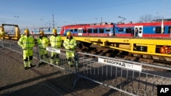 Workers await the ceremony of the reconstruction of a railway line between Budapest and Belgrade, in Belgrade, Serbia, Nov. 28, 2017.