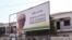 Deux hommes se tiennent devant un panneau du candidat présidentiel de l'opposition Umaro Sissoco Embalo à Bissau, le 27 décembre 2019, à l'approche du second tour des élections présidentielles. (AFP)