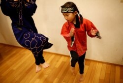 Indigenous Ainu Teruyo Usa's daughter Ruino practices a traditional Ainu dance before performing at a folk art concert in Tokyo, Japan, May 17, 2019.