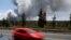 As a car dashes by, an ash plume rises from the Halemaumau Crater on Kilauea's summit, near Volcano, Hawaii, May 25, 2018. 