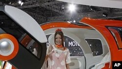 A model sits on Suzuki Motor Corp.,'s concept car "Q-Concept" during the press preview of Tokyo Motor Show in Tokyo.