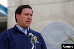 FILE - Florida Governor Ron DeSantis speaks to the media as Hurricane Dorian approaches the state, at the National Hurricane Center in Miami, Aug. 29, 2019.