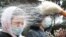 An Orthodox priest sprays holy water on believers after a service which marks the Orthodox feast of Palm Sunday, amid the coronavirus disease (COVID-19) outbreak, outside the Volodymyrsky Cathedral in Kyiv, Ukraine April 25, 2021.