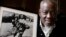 Le photographe sud-africain Sam Nzima pose avec sa photo emblématique montrant Hector Pieterson, 13 ans, porté après avoir été abattu par la police de l'apartheid lors du soulèvement de Soweto en 1976, à Pretoria, le 27 avril 2011.