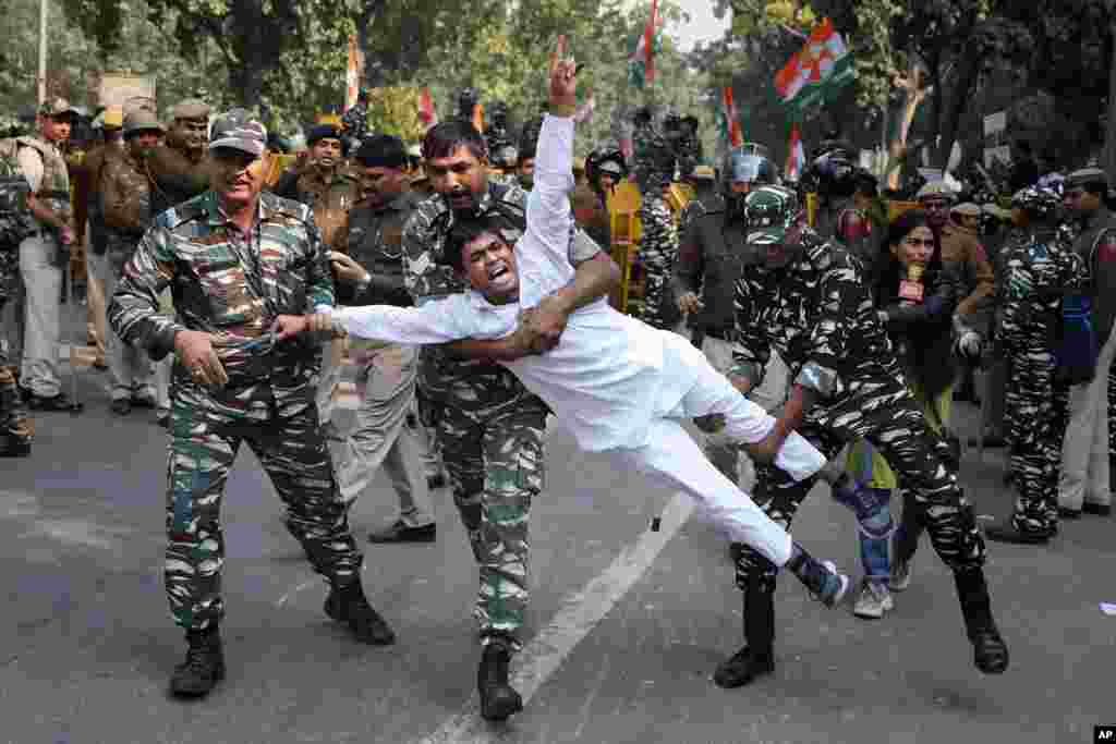  Paramilitary soldiers detain a Congress party supporter during a protest in New Delhi, India, against the withdrawal of Special Protection Group cover to party president Sonia Gandhi, her immediate family members and former Prime Minister Manmohan Singh.