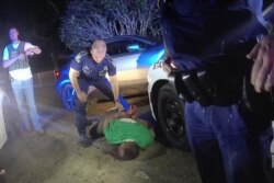 FILE - This image from video from Louisiana state trooper Lt. John Clary's body-worn camera shows trooper Kory York standing over Ronald Greene on his stomach on May 10, 2019, outside of Monroe, La.