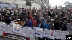 Pakistani protesters condemn the suicide bombing at the Lal Shahbaz Qalandar shrine, in Lahore, Pakistan, Feb. 17, 2017. Pakistani forces killed and arrested dozens a day after a massive suicide bombing by the Islamic State group killed dozens of worshipp
