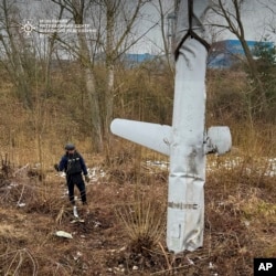 In this photo provided by the Ukrainian Emergency Service, pyrotechnists examine an X-55 Russian cruise missile that was shot down in Kyiv, Ukraine, on Nov. 28, 2024.