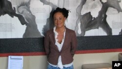 File - Rachel Dolezal, president of the Spokane, Washington, chapter of the NAACP, stands in front of a mural she painted, in Coeur d'Alene, Idaho.