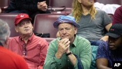 FILE - Actor Bill Murray, center, is seen at an NCAA college basketball game in Tallahassee, Florida, Feb. 24, 2020. Murray is joining other actors for an online reading of a religious text with remarkable relevance to the current moment.