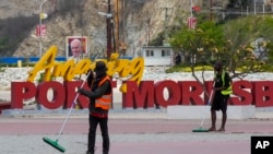 Workers sweep a path near a venue where Pope Francis will visit later this week in Port Moresby, Papua New Guinea, Sept. 5, 2024.