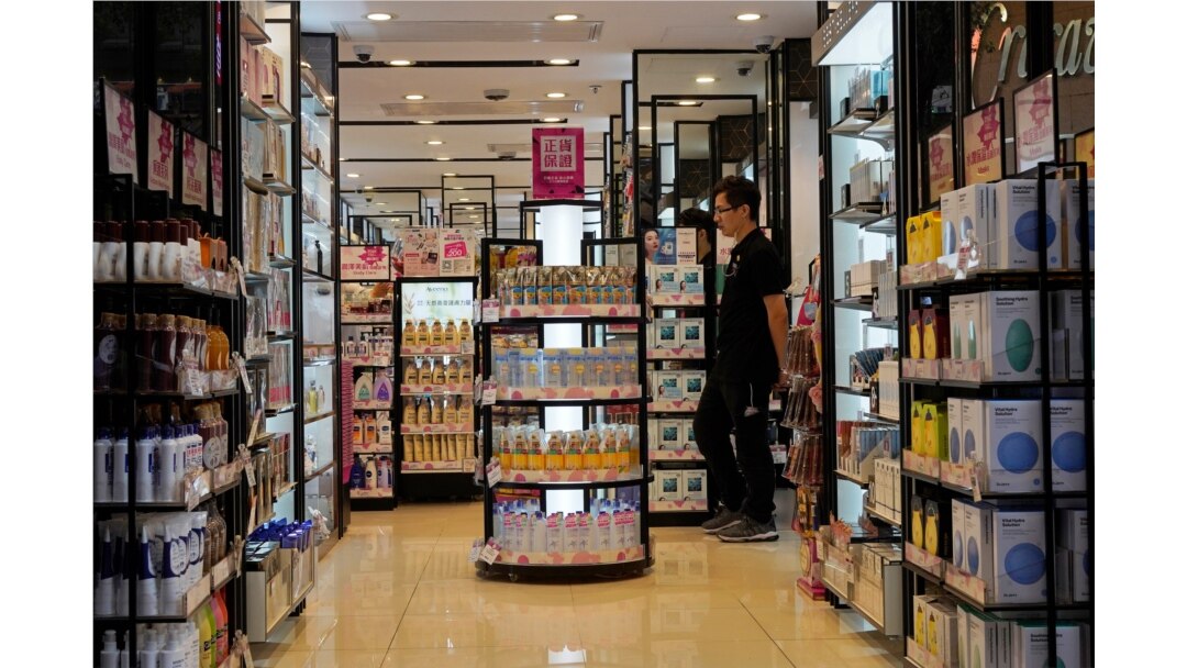 FILE - A salesman waits for customers at a cosmetic shop in a shopping district in Hong Kong, Oct. 30, 2019.