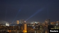 Ukrainian service personnel use searchlights as they look for drones in the sky over the city center during a Russian drone strike, amid Russia's attack on Ukraine, in Kyiv, Ukraine, Oct. 21, 2024.