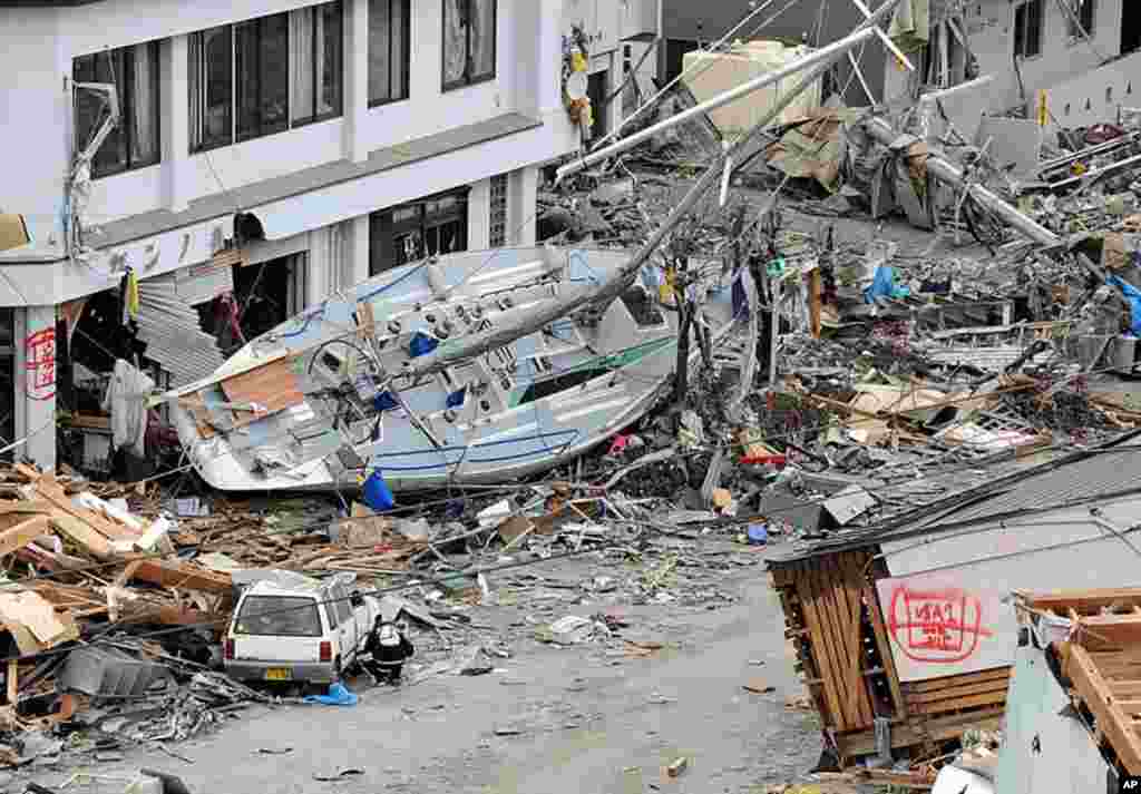 A yacht lies beside a building in the devastated city of Ofunato, Iwate prefecture as the country struggles to cope following the earthquake and tsunami disasters, March 15, 2011. (AFP)
