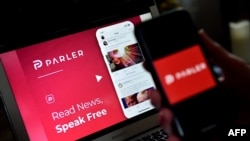 FILE - The Parler logo is displayed on a smartphone with its website in the background, July 1, 2020.