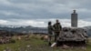 FILE - Members of Greece's military geographical team conduct geological measurements, to evaluate potential structural changes due to the ongoing seismic activity on the volcanic island of Nea Kameni, Greece, Feb. 10, 2025.