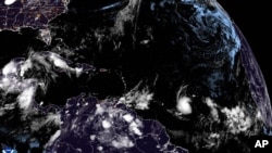 This National Oceanic and Atmospheric Administration satellite image taken early on June 29, 2024, shows Tropical Storm Beryl, lower center right, as it strengthens over the Atlantic Ocean.