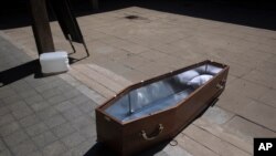 An open coffin lies on the ground at a special morgue for COVID-19 victims in the central Israeli city of Holon, near Tel Aviv, Sept. 23, 2020. 