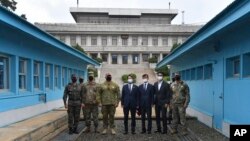 Menteri Unifikasi Korea Selatan Lee In-young (tengah), dan pejabat berpose dengan tentara AS dan Korea Selatan di garis demarkasi militer selama kunjungan ke Panmunjom di Zona Demiliterisasi, Korea Selatan, Rabu, 16 September 2020.