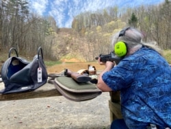 Rob Weaver steadies his gun for target practice. Weaver, a former owner of a gun range in Maryland, is against gun regulations, saying guns are not the problem. "The problem is people who have ill intent, doing bad things." (Carolyn Presutti/VOA)