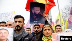 Muškarac drži fotografiju Mira Perwera (Mehmet Sirin Aydin), koji je ubijen u pucnjavi, dok se članovi kurdske zajednice okupljaju na trgu Place de la Republique u Parizu, Francuska, 24. decembra 2022. REUTERS/Sarah Meyssonnier