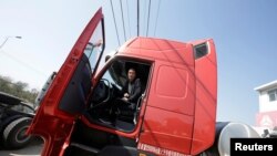 Sales manager Nie Liliang sits in an LNG truck in Yutian county, China