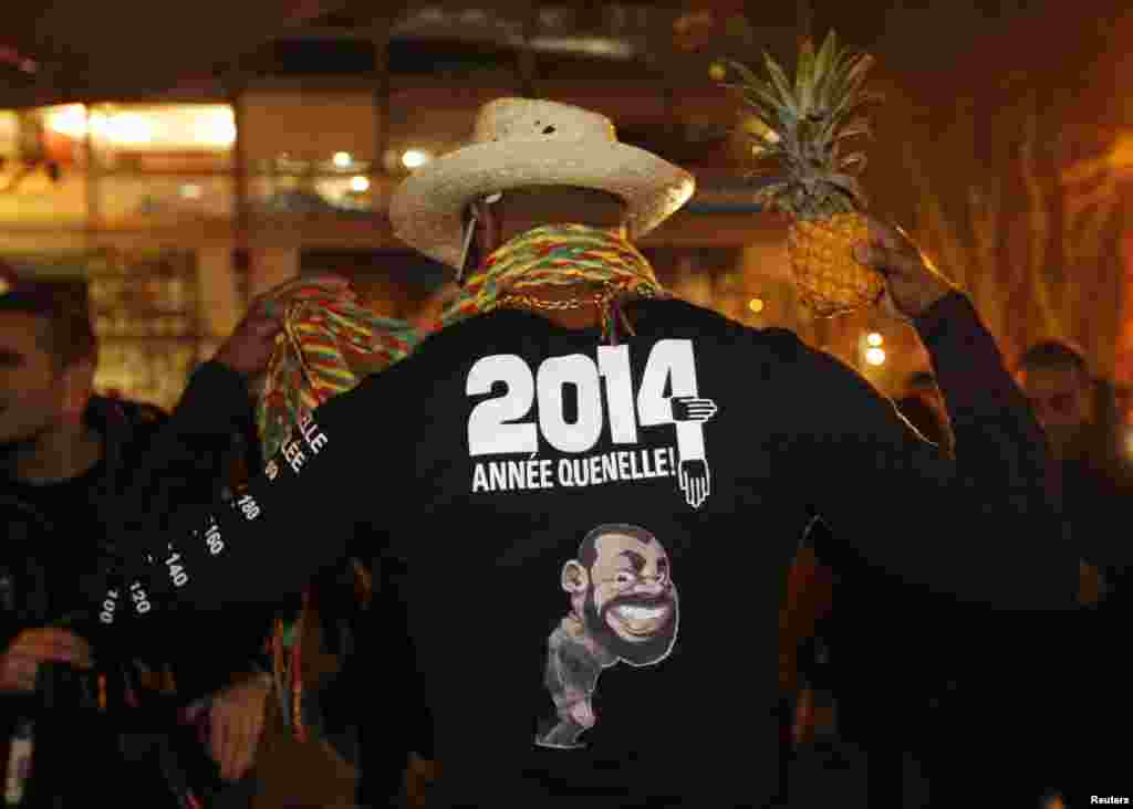 A fan of French comedian Dieudonne M&#39;bala M&#39;bala, also known as Dieudonne, wears a shirt with the message, &quot;2014, Year of the quenelle&quot; outside the concert hall where the humorist was to hold his show in Tours.&nbsp; A court upheld a ban on the show scheduled for Friday. The has been comedian accused of insulting the memory of Holocaust victims. 