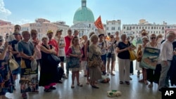 Activistas se congregan afuera de la estación de trenes de Santa Lucía, en Venecia, el 13 de julio de 2024, para protestar contra la tarifa para visitantes de un día. (ARCHIVO: AP)