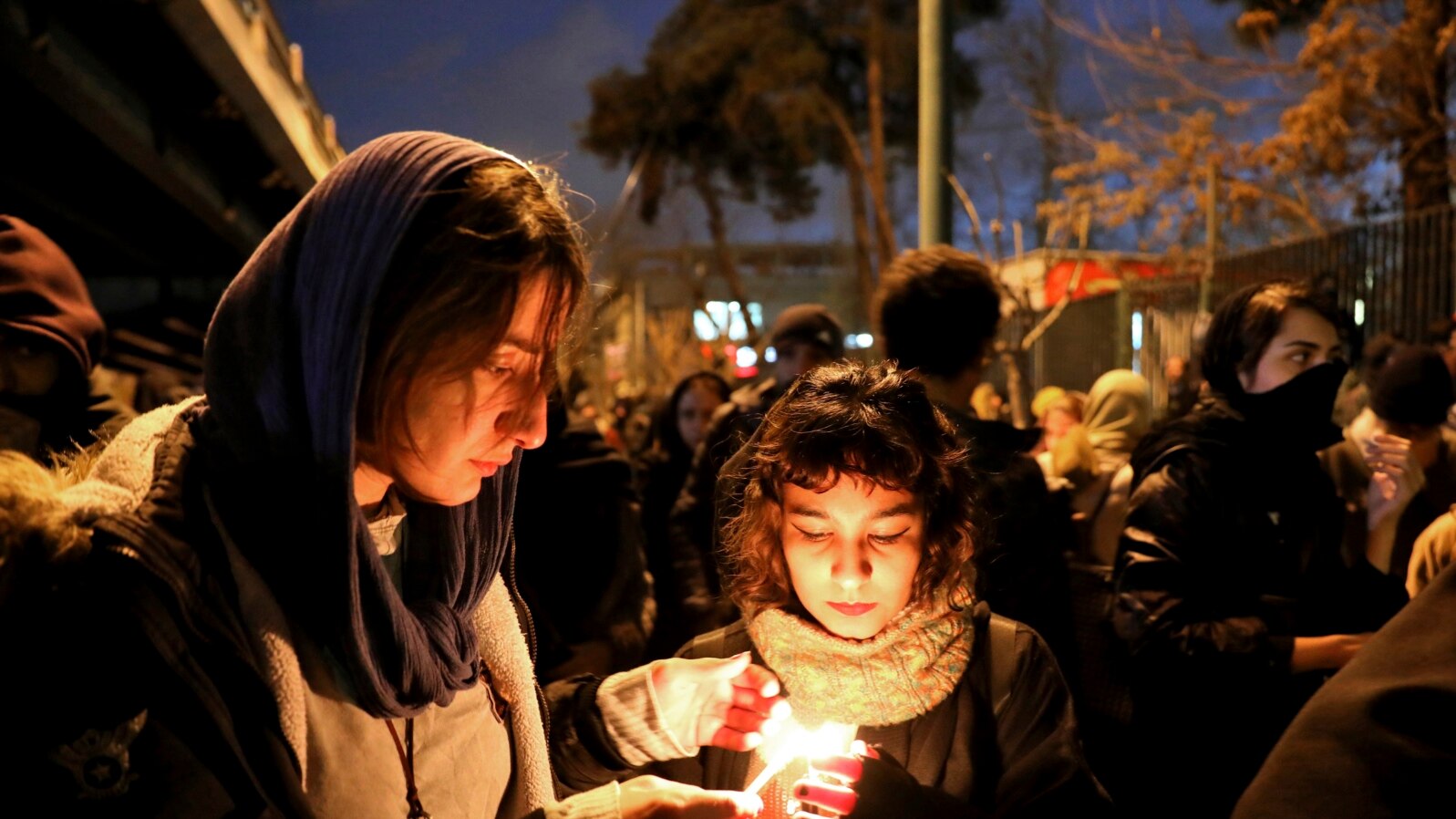 People gather for a candlelight vigil for the victims of the Ukraine plane crash, at the gate of Amri Kabir University that some of the victims of the crash had attended, in Tehran, Iran, Jan. 11, 2020.