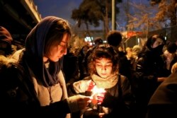 People gather for a candlelight vigil to remember the victims of the Ukraine plane crash, at the gate of Amri Kabir University that some of the victims of the crash were former students of, in Tehran, Jan. 11, 2020.