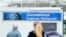People stand in front of containers with a banner reeding "Coronavirus Diagnosis Base" on the grounds of the University Hospital in Mannheim, Germany, March 11, 2020.