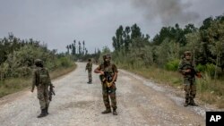 Indian army soldiers stand guard near the site of a gunbattle in Pulwama, about 35 kilometers south of Srinagar, in Indian-controlled Kashmir, Aug. 26, 2017.