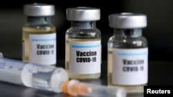 ແກ້ວຢາຂະໜາດນ້ອຍທີ່ມີກາ "Vaccine COVID-19" ຕິດໃສ່ ແລະ ເຂັມສັກຢາ. 10 ເມສາ, 2020. 