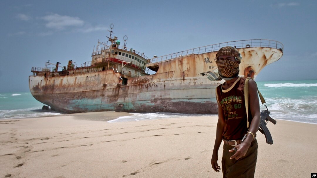 Dalam foto tertanggal 23/9/2012 ini seorang perompak Somalia berdiri di depan kapal Taiwan yang terhempas ke pantai di daerah Hobyo, Somalia. 