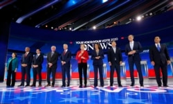 Democratic U.S. presidential candidates, from left, Senator Amy Klobuchar, Senator Cory Booker, South Bend Mayor Pete Buttigieg, Senator Bernie Sanders, former Vice President Joe Biden, Senator Elizabeth Warren, Senator Kamala Harris, entrepreneur Andrew Yang, former Rep. Beto O'Rourke and former Housing Secretary Julian Castro pose before the start at the 2020 Democratic U.S. presidential debate in Houston, Sept. 12, 2019.