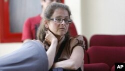 FILE - Lori Berenson sits in a migration office in Lima. Berenson was sentenced to life in prison for helping the Tupac Amaru leftist rebel group plan an armed takeover of Congress.