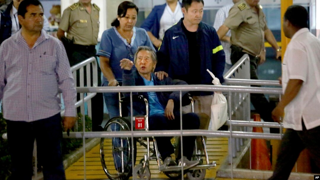 El expresidente Alberto Fujimori sale en silla de ruedas de la clínica en la que estaba internado en Lima, Perú. Le acompaña su hijo, Kenji (chaqueta azul).