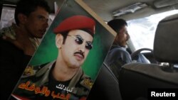 A poster of Ahmed Ali Abdullah Saleh, the son of Yemen's former President Ali Abdullah Saleh, is pictured inside a car of a supporter during a demonstration to demand for presidential elections to be held and for him to run for presidency in Sana'a, March 10, 2015.